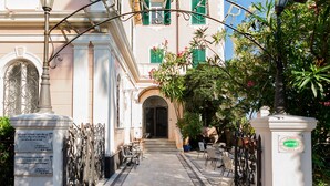 A cobblestone pathway leading to a building with a classic facade, green shutters, and a central entrance. - Hotel Miramare - Spotorno (Spotorno)