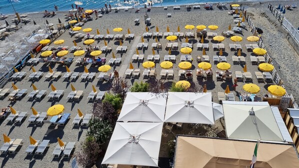 A beach with rows of sunbeds and umbrellas, some with white canopies. - Hotel Miramare - Spotorno (Spotorno)