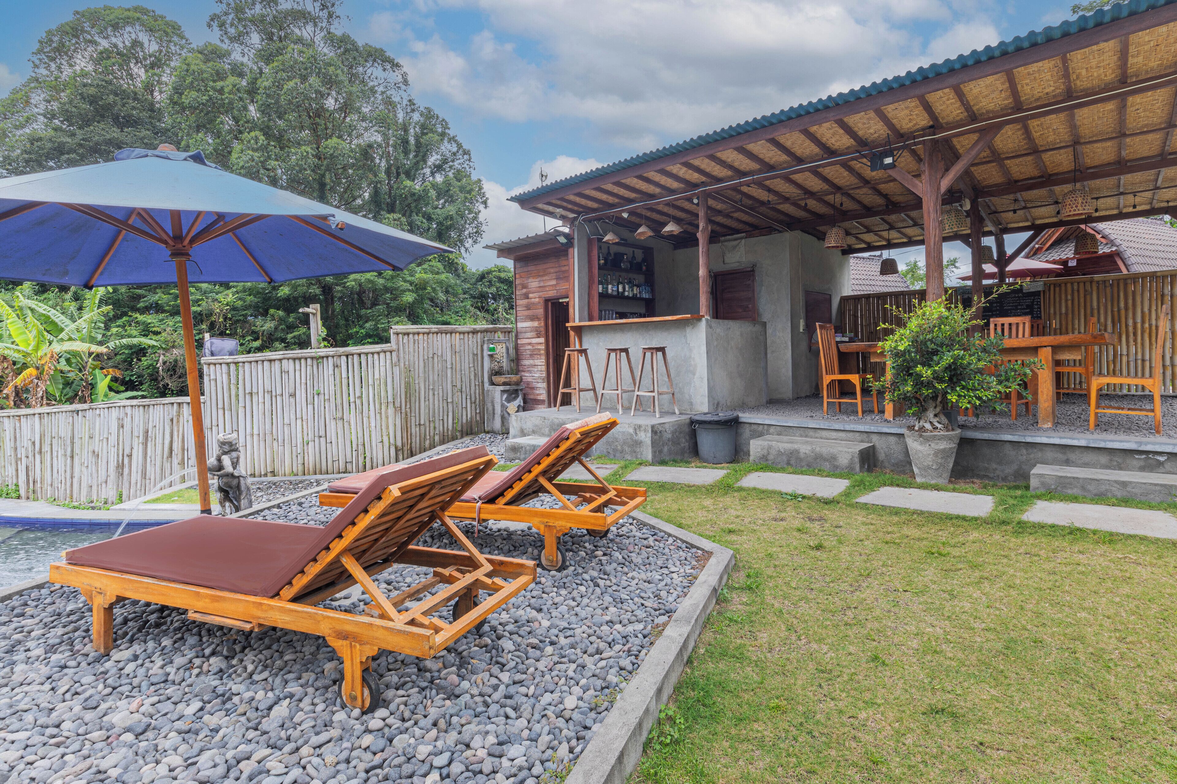 Un patio con sillas de descanso, un bar y un espacio de estar techado.