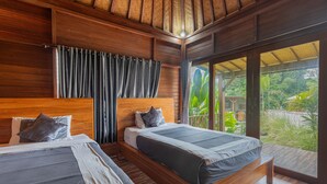 A bedroom with two beds, wooden headboards, and a large window with a view of greenery. - Cabana Bali Villa (Kintamani)