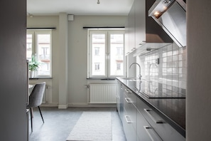 Business appartement | Privékeuken | Een koelkast met diepvriezer, een microgolfoven, een oven, een kookplaat