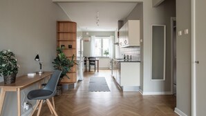 A modern kitchen with white cabinets, a wooden dining table, and a gray chair.