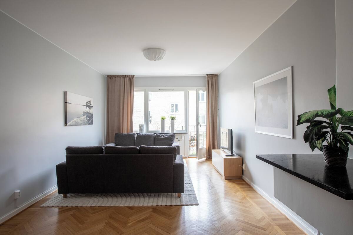 A modern living room with a sofa, a coffee table, and a potted plant.