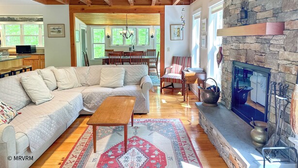 A cozy living room with a sectional sofa, a wooden coffee table, and a stone fireplace.
