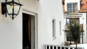 Un bâtiment blanc avec une lanterne noire, une porte et une fenêtre.