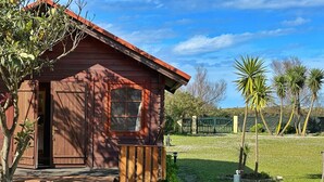 A rustic cabin with a wooden exterior, a porch, and a stone foundation. - Casa Primera Línea en Berria - Chalet Pitu 17801 (Berria)