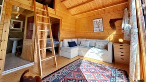 A cozy cabin interior with a wooden ceiling, a sofa set, a ladder, and a patterned rug. - Casa Primera Línea en Berria - Chalet Pitu 17801 (Berria)