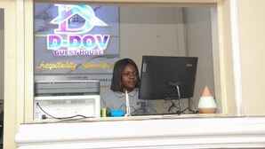 A guest service desk with a computer, a telephone, and a small plant. - D Dov Guest House (Port Harcourt)