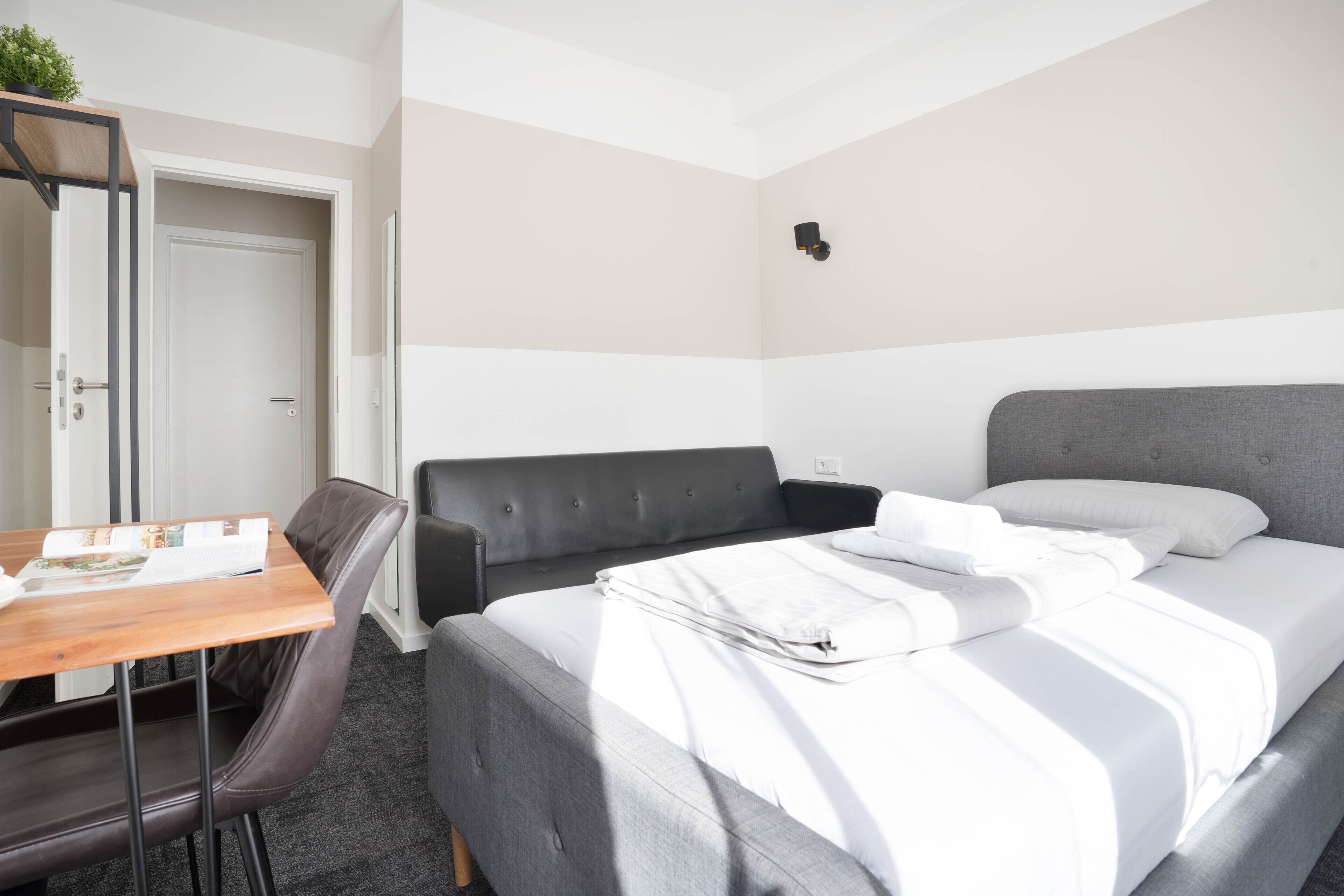Une chambre d’hôtel moderne, équipée d’un lit, d’un bureau et d’une chaise.