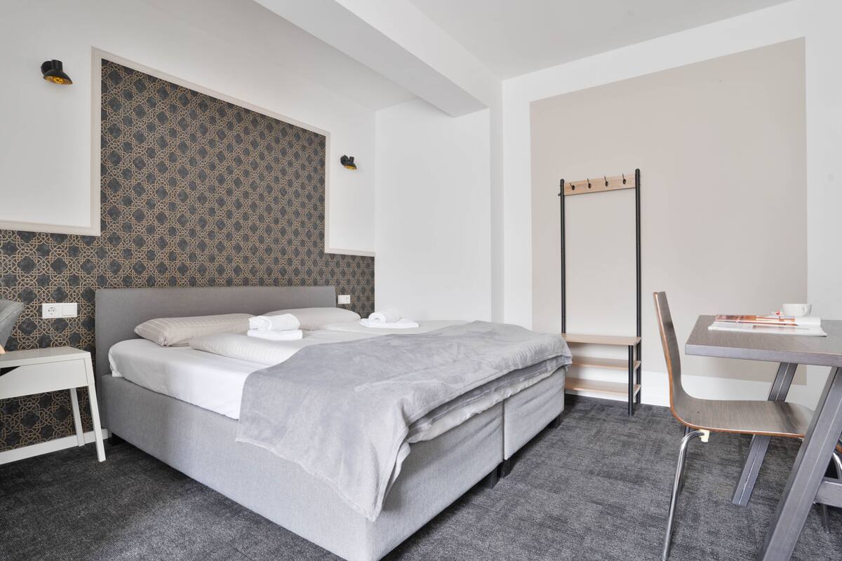 Een moderne hotelkamer met een groot bed, een bureau en een stoel.