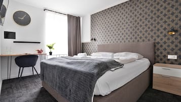 Una habitación de hotel moderna con una cama grande, un escritorio y una silla.