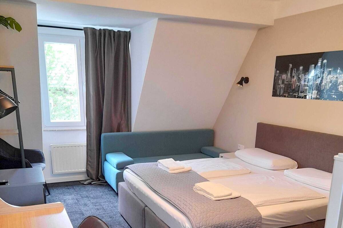 Een moderne hotelkamer met een groot bed, een bureau en een zithoek.