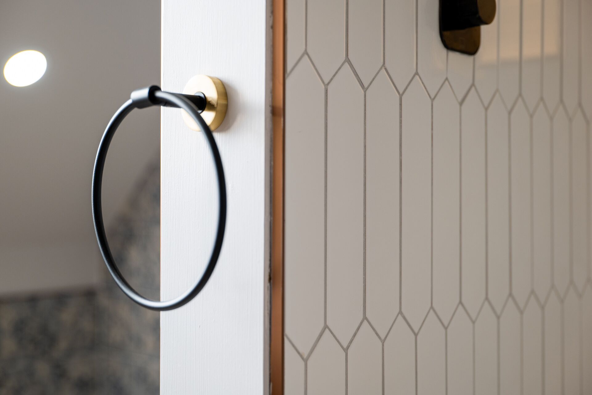 A door with a towel ring and a geometric patterned wall.