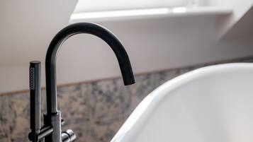 A modern bathroom with a black faucet and a white bathtub.