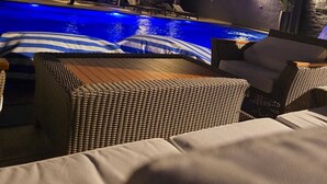 En modern byggnad med en swimmingpool och ett utomhusområde med sittplatser.