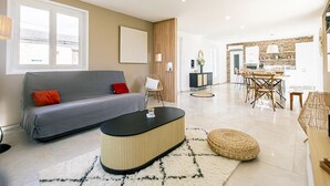 Un salon moderne comprenant un canapé, une table basse et un coin repas avec des chaises et une table.