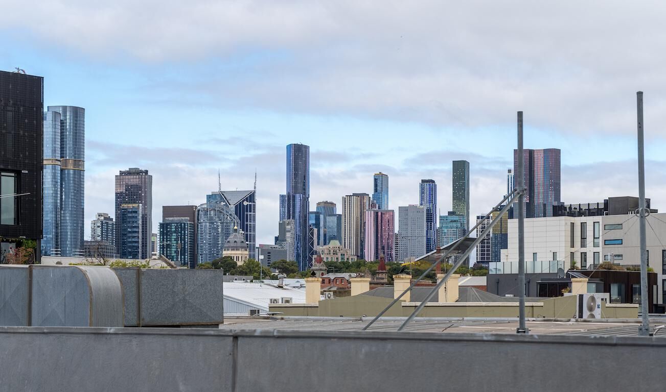 Une vue sur les toits d’une ville, avec des immeubles modernes et des gratte-ciel, et un mélange de styles architecturaux.