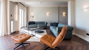Un salon moderne comprenant un canapé, une table basse et un fauteuil en cuir.