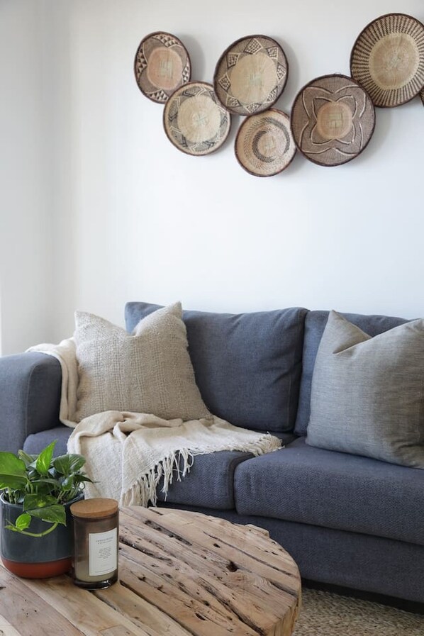 A living room with a grey sofa, a wooden coffee table, and a wall decorated with circular wall art.