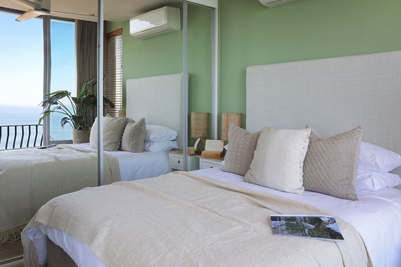 Ein Hotelzimmer mit zwei Betten, einem großen Fenster mit Ausblick und einem Balkon.