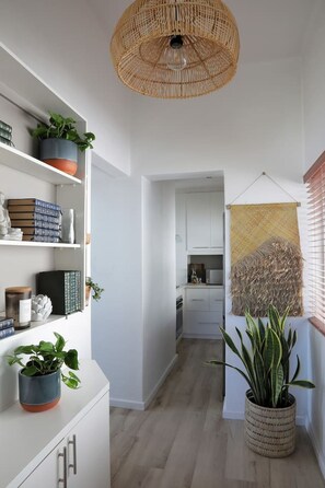 A modern kitchen with white cabinets and a hanging light fixture. - Cozy Studio Apartment - Number 4705 (Cape Town)