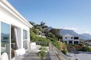 A modern house with a balcony overlooking a mountainous landscape. - Beach House - Number 49 (Cape Town)