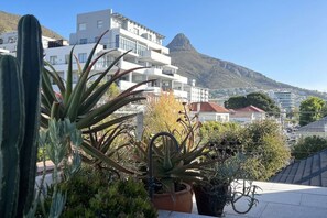 A building with multiple balconies and a mountain in the background.