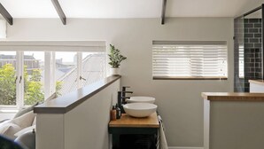Een moderne badkamer met dakraam, groot raam en stadszicht.
