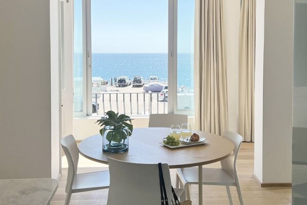 A dining area with a table, chairs, a potted plant, and a tray with food and drinks.