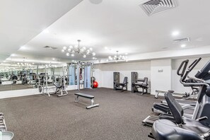 A gym with various exercise equipment, a bench, and a large mirror. - Brand New! Luxe 3BR In Aotea Square I Zodiak Stays (Auckland)