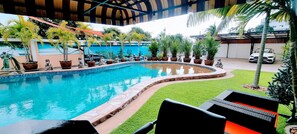 Relax by the serene pool surrounded by lush greenery and comfortable seating.