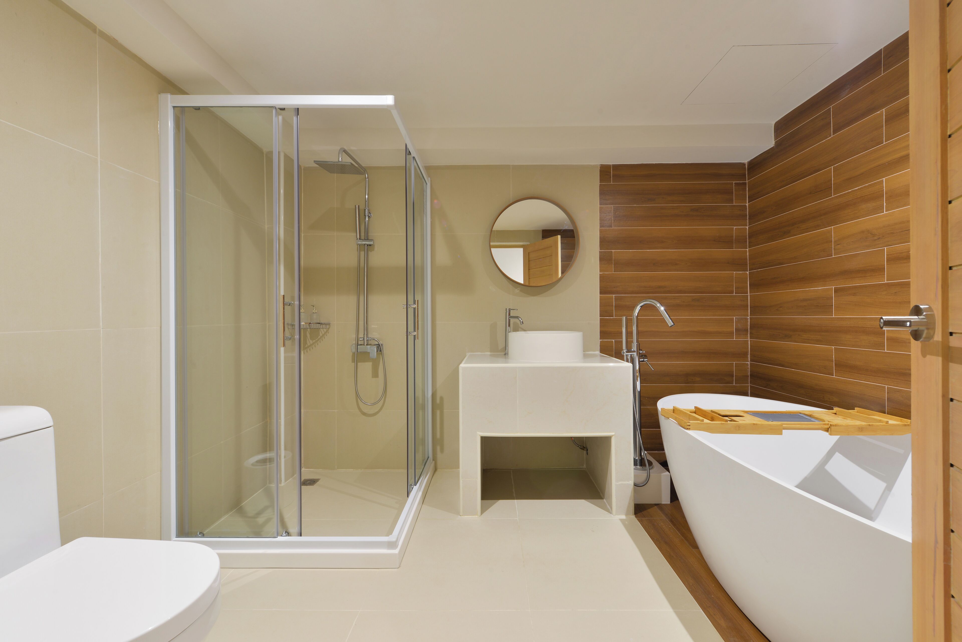 Een moderne badkamer met een douchekabinet van glas, een wit wastafelmeubel en een vrijstaand bad.