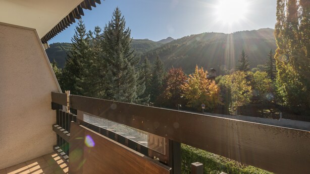 Ein Balkon mit Blick auf Berge und Bäume.