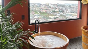 A room with a large window, a wooden barrel bath, and a view of a cityscape. - 9 Inn - Staycation in Am Am Dalat (Xuan Huong - Da Lat)