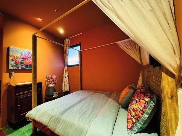 Un dormitorio con cama, mesita de noche, lámpara, un cuadro y ventana con cortinas.