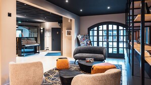 A modern interior with a seating area, a piano, and a staircase. - Base Camp Lodge - Albertville (Albertville)