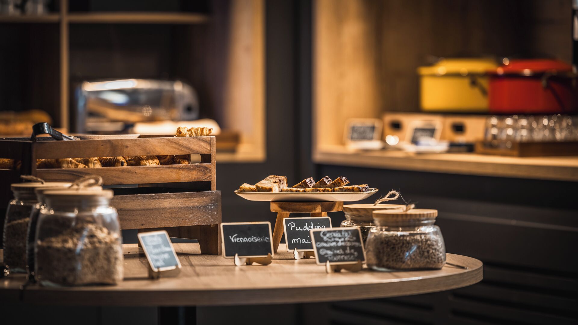 Una mesa de postres con diversos dulces y un cartel que indica 'Pudding' y 'Viennoiserie'.