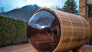 A wooden sauna with a large glass dome, set on a wooden deck with a mountain backdrop. - Base Camp Lodge - Albertville (Albertville)