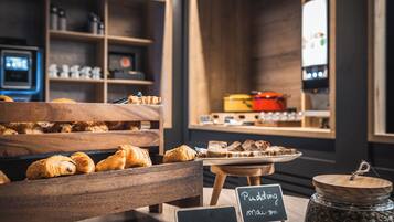 A bakery display with pastries and a jar of seeds.