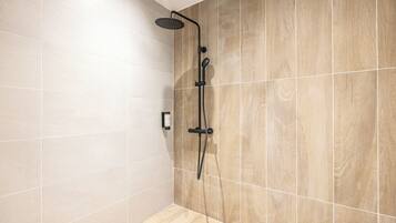 A modern shower area with a rain showerhead, a handheld showerhead, and a handheld massager.