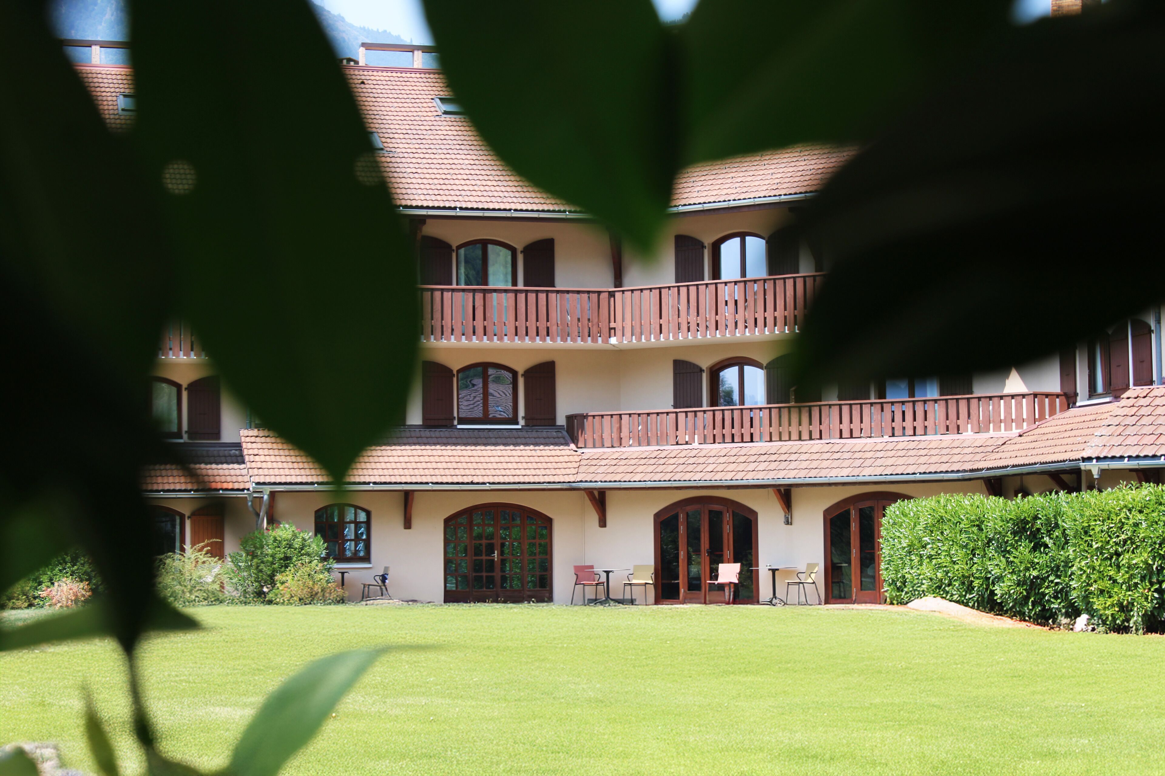 A multi-story building with a courtyard, featuring a balcony on the upper floor.
