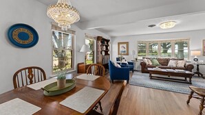 A spacious living room with a dining area, a chandelier, and a view of the outdoors. - Vintage Veranda - Ping Pong Table & More! (Fredericksburg)