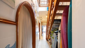 A narrow hallway with wooden doors and a staircase on the right. - KITE & SURF NOMAD HOUSE (Las Palmas de Gran Canaria)