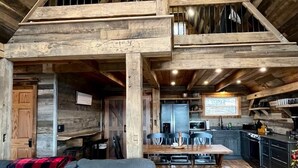 A spacious loft with a high ceiling, exposed wooden beams, a dining area, and a kitchen. - Estill Oaks - Luxe Mountain View Retreat -Hot Tub - Secluded 80-Acre Escape for 16 Guests (Estill County)