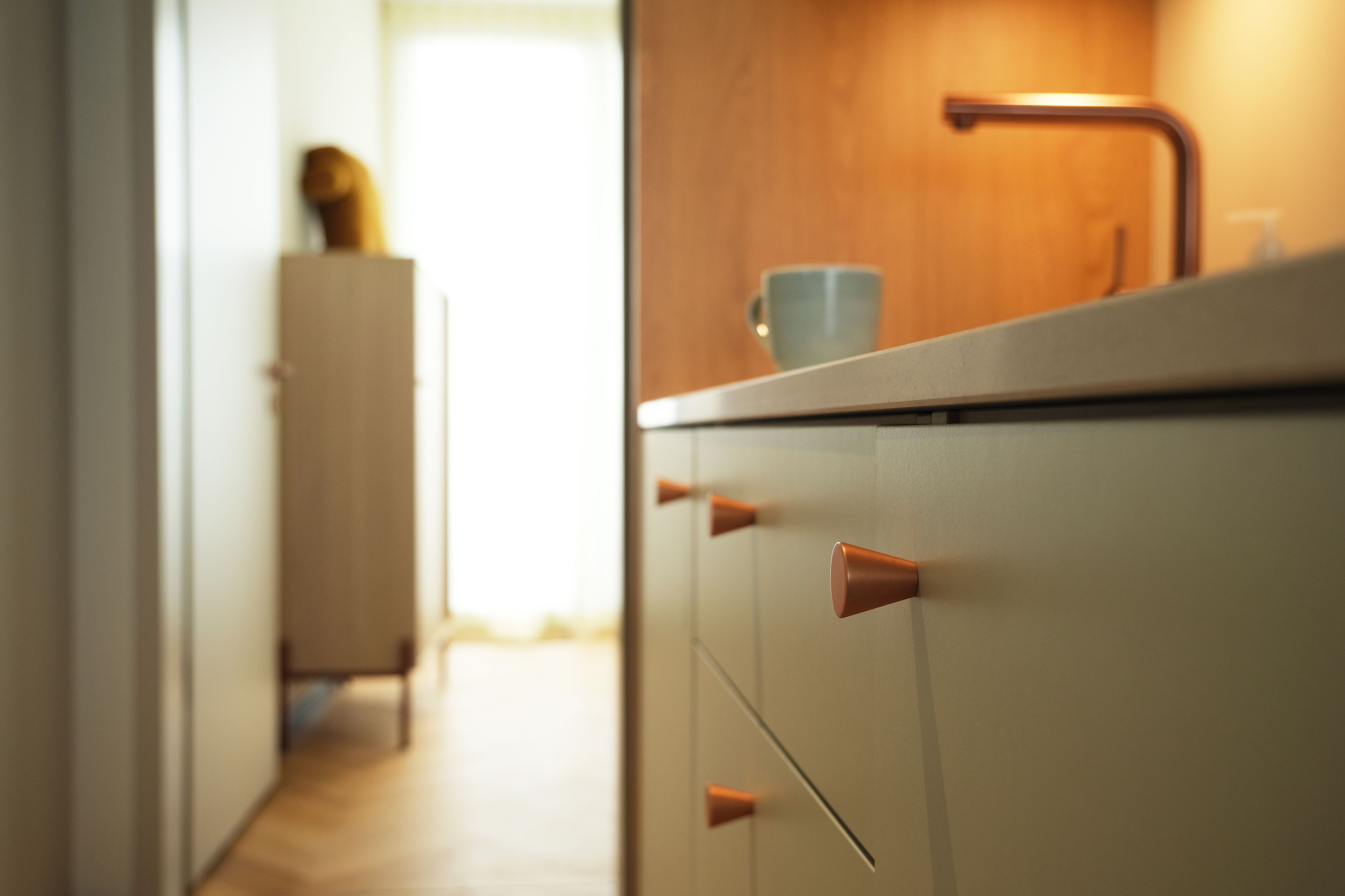 A kitchen with a wooden countertop, a sink, and a cabinet with drawers.