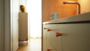 A kitchen with a wooden countertop, a sink, and a cabinet with drawers.