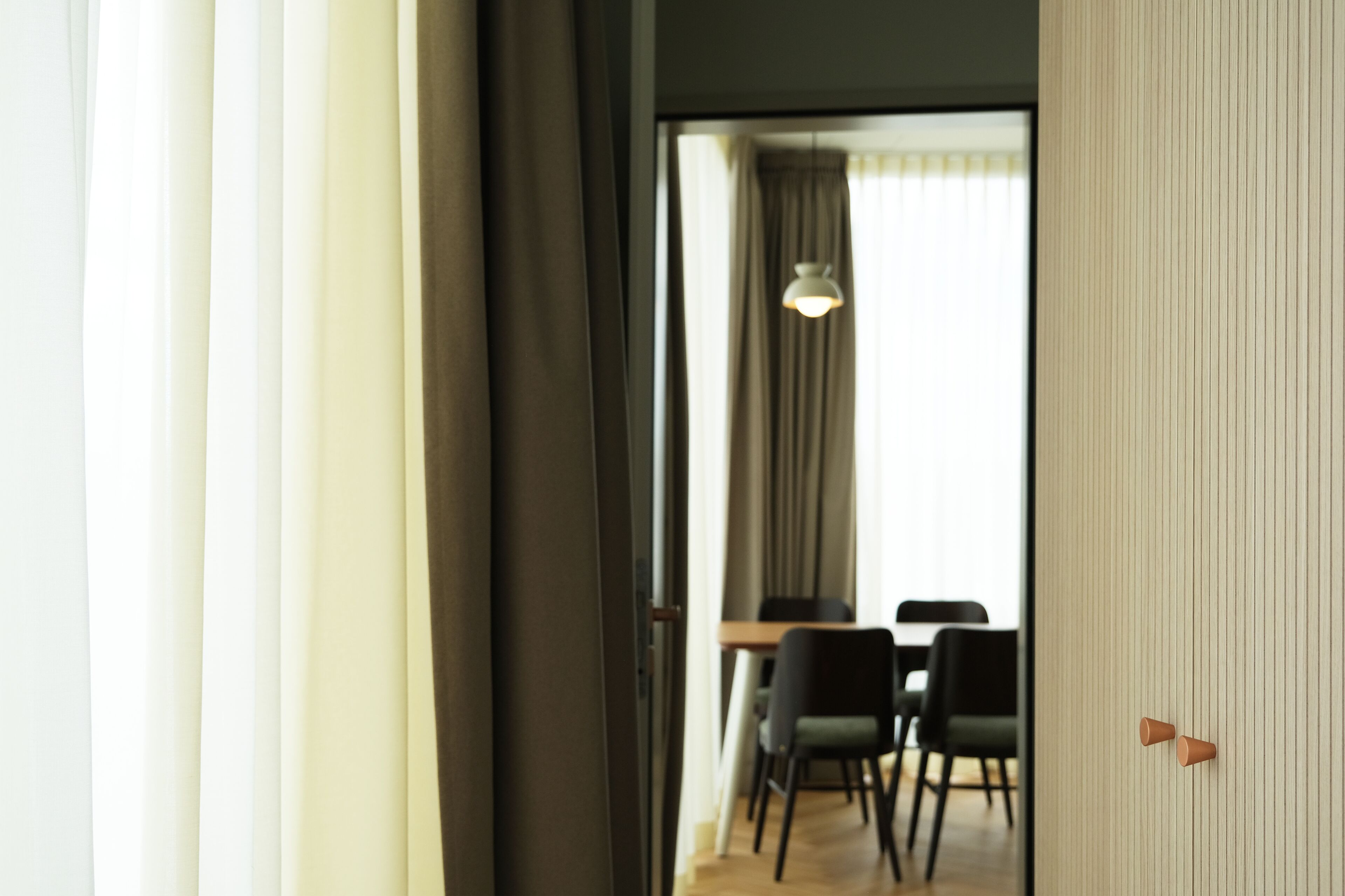 Una habitación con comedor, una mesa, sillas y una lámpara colgante.