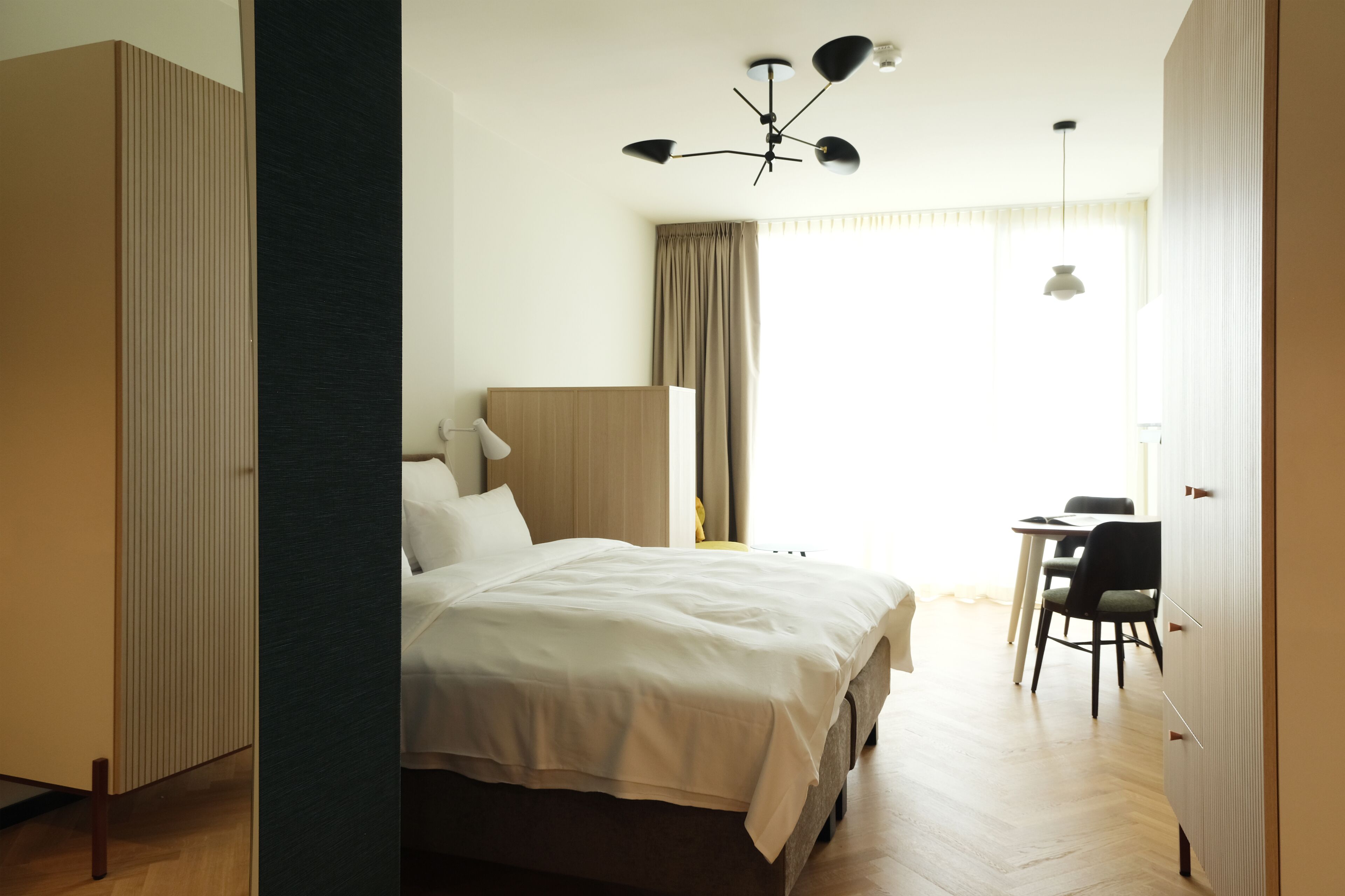 Una habitación de hotel con una cama, un escritorio y una silla.
