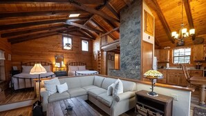 Een gezellig cabin-interieur met een grote L-vormige bank, een eettafel en een keukenhoek.