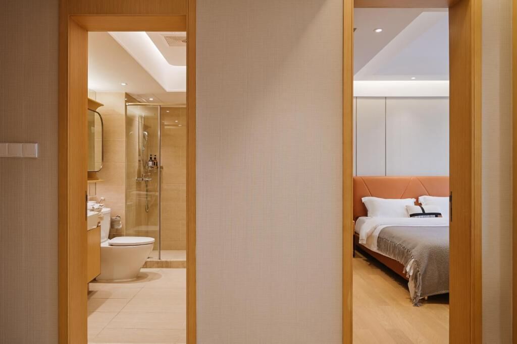 Une salle de bain moderne équipée de toilettes, d’un lavabo et d’une douche à parois de verre.